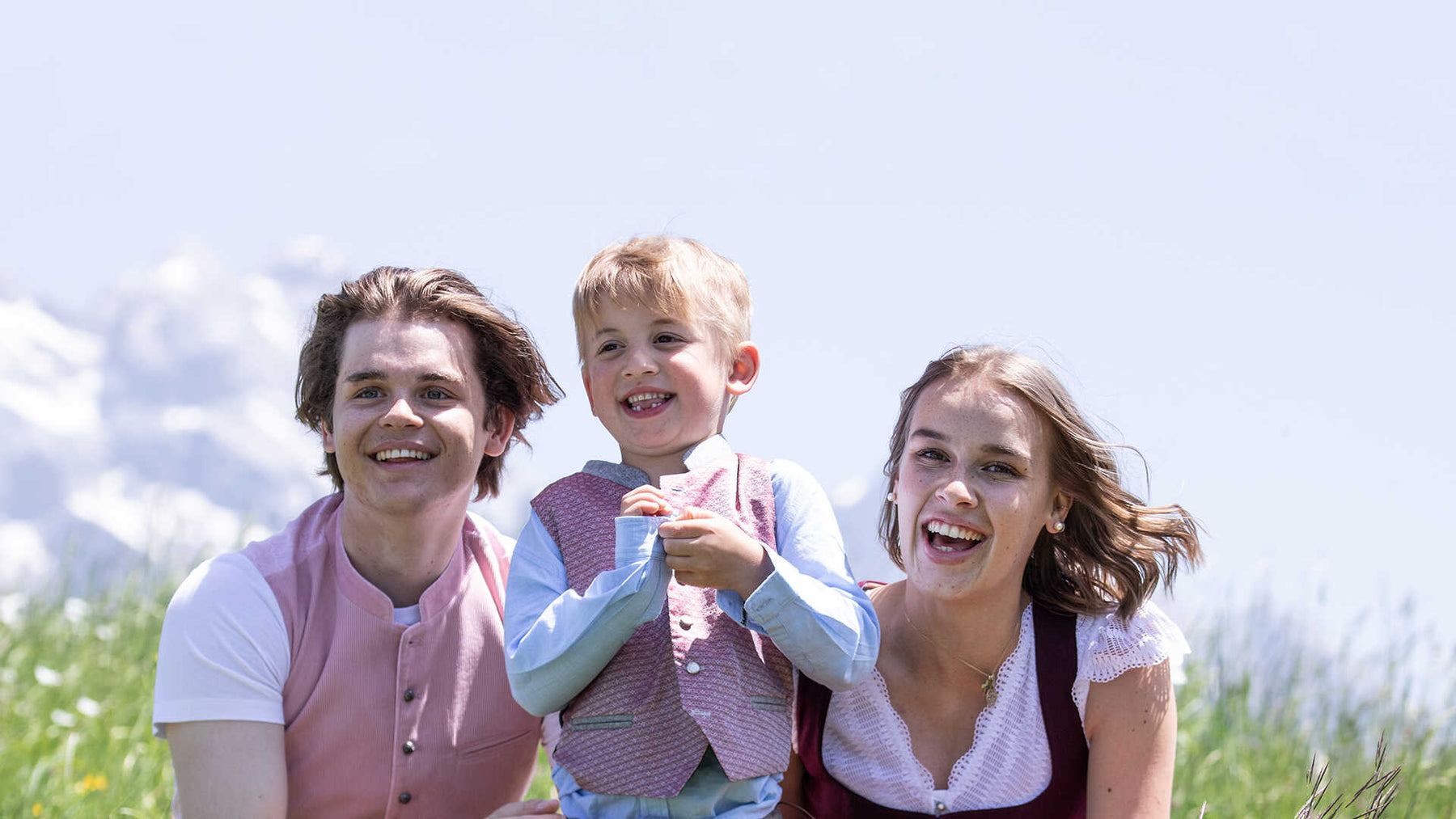 Familie in Tracht auf einer Almwiese