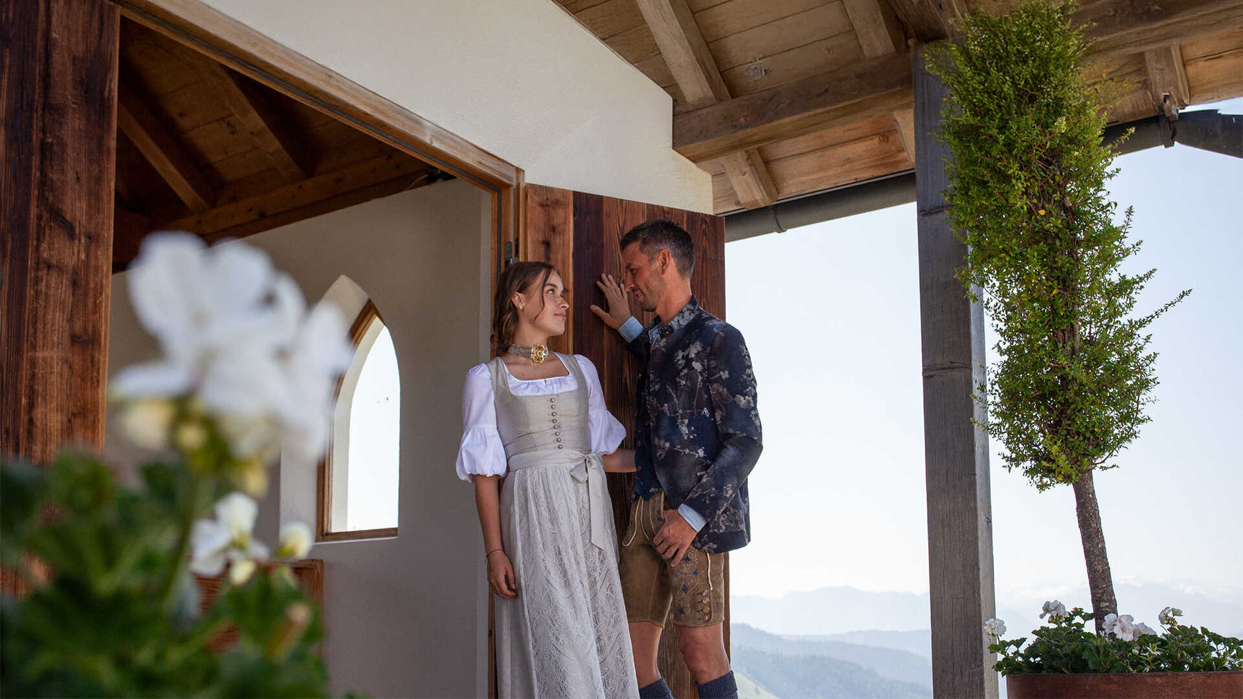 Paar in moderner Tracht vor alpiner Kulisse